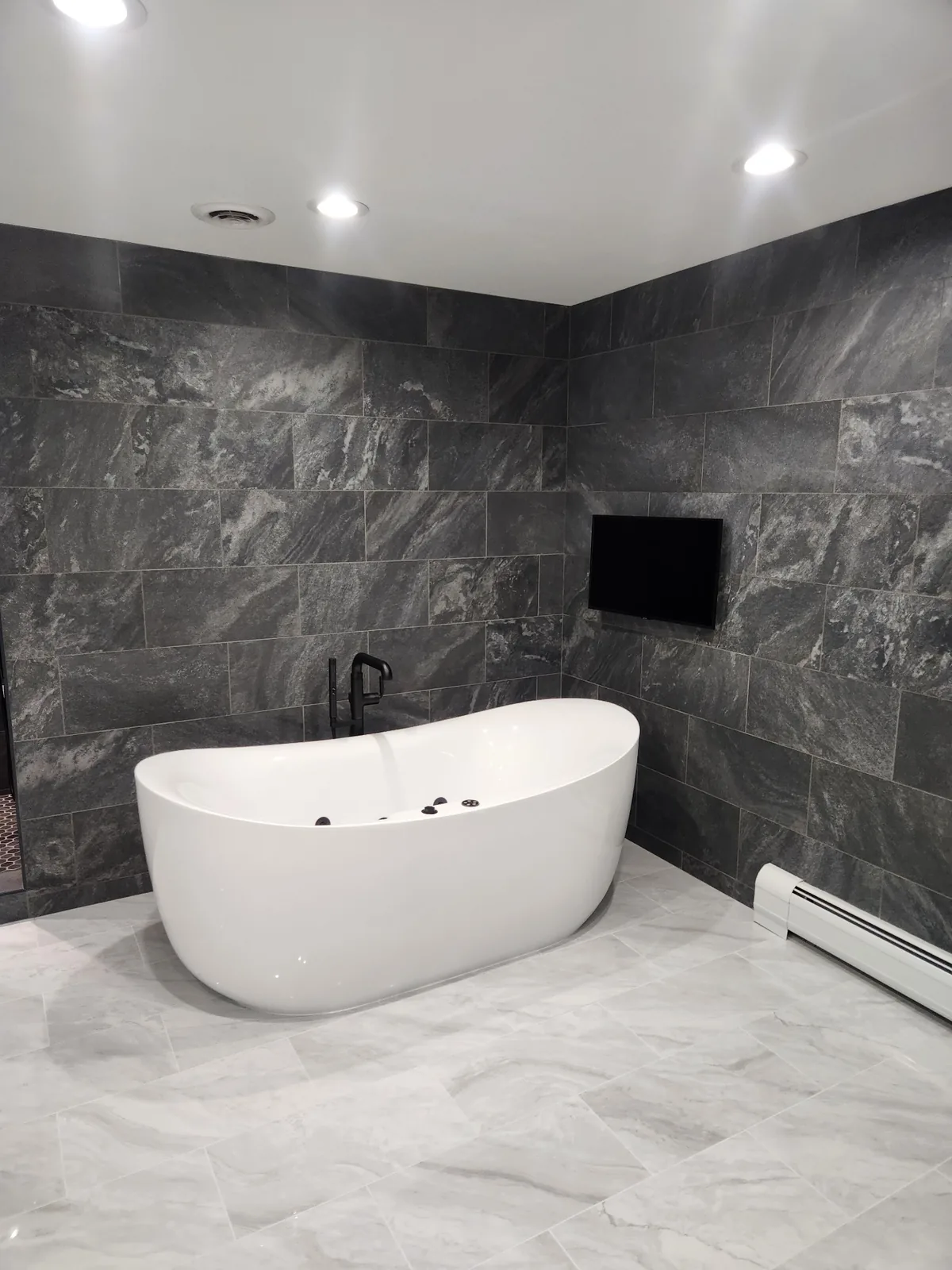 Modern bathroom remodel with slate tile and freestanding tub in Bergen County NJ
